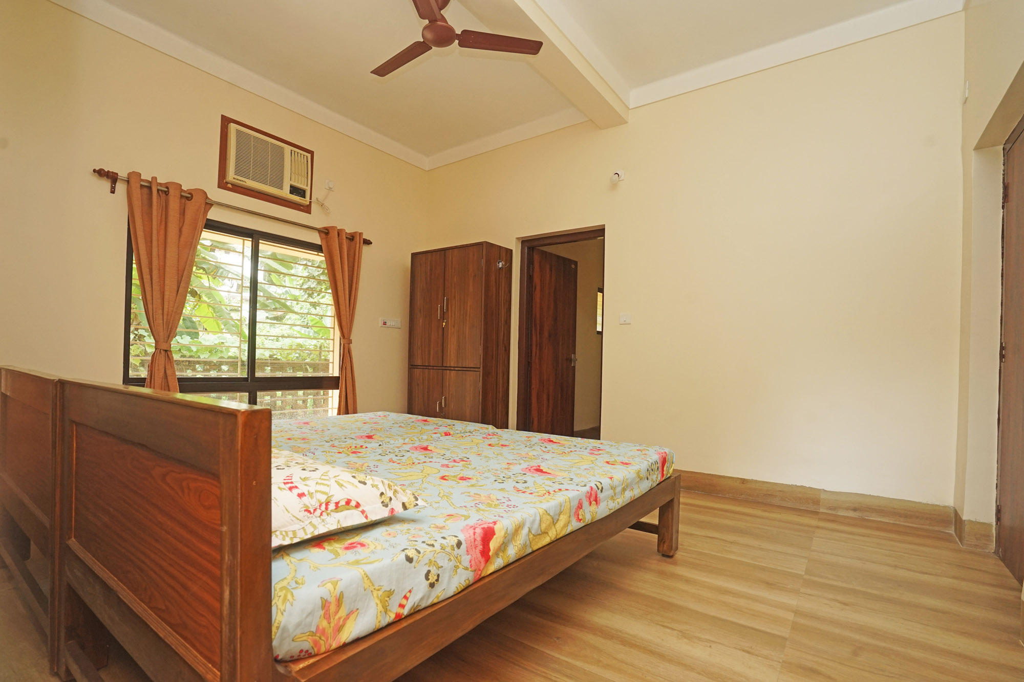 Premium bedroom at Shanti Niwas with twin beds and warm lighting.