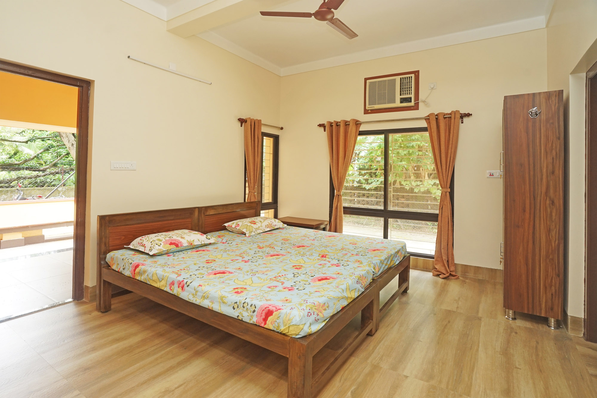 Deluxe bedroom at Shanti Niwas with twin beds and large windows.